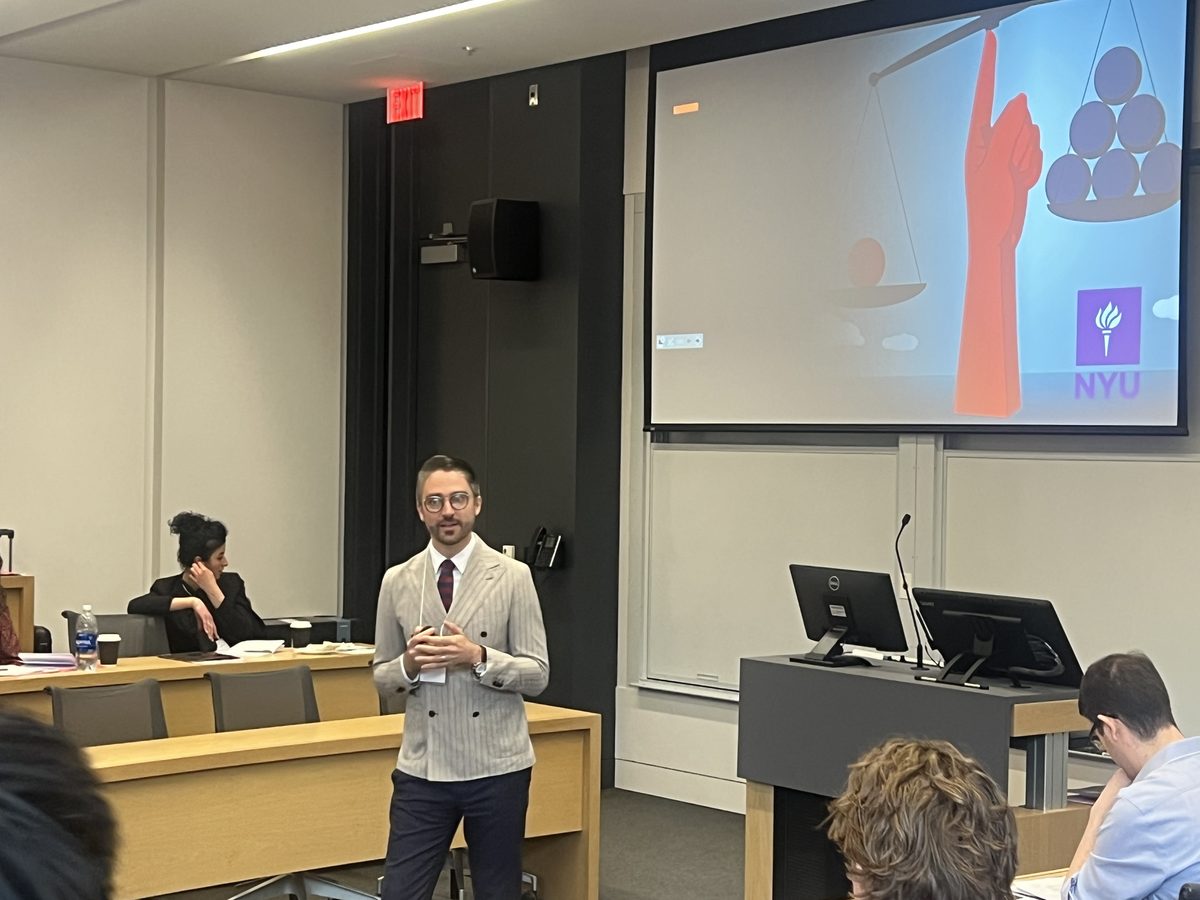 A presenter speaking beside a projected slide at the 2nd MEM Conference, Rotman School, April 2025